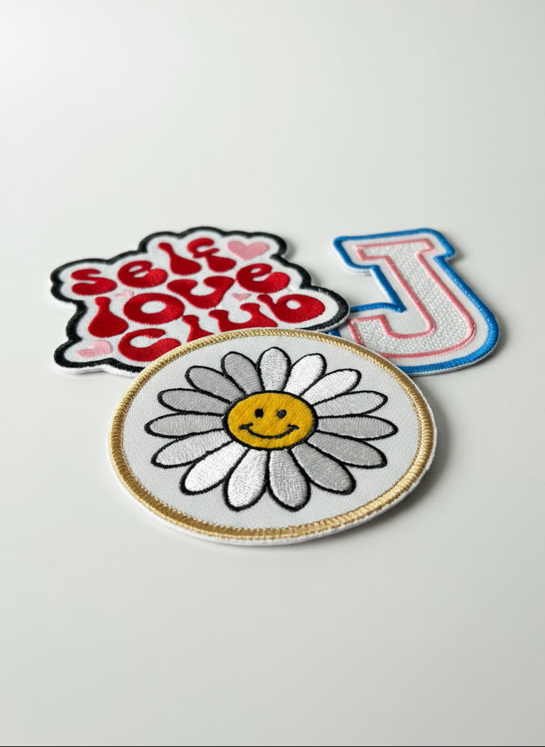 Flower-shaped patch with smiley face on white background